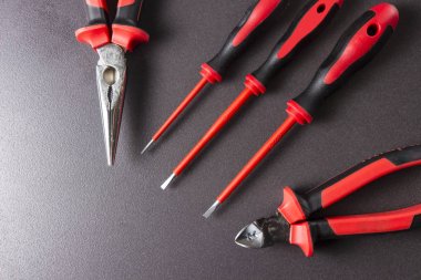 Araçlar elektrikçi Tornavidalar, pense, siyah bir arka plan platypuses.