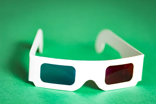 3D-Brille aus Papier auf grünem Hintergrund. Der Film in 3D. Kinozubehör. — Stockfoto