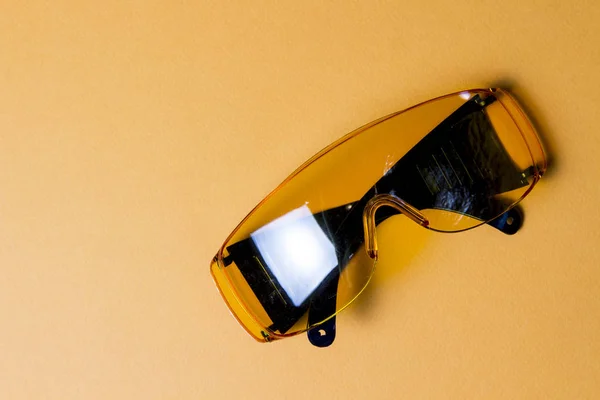 Gelbe Schutzbrille auf gelbem Hintergrund. Accessor Builder Brille für die Augensicherheit. — Stockfoto