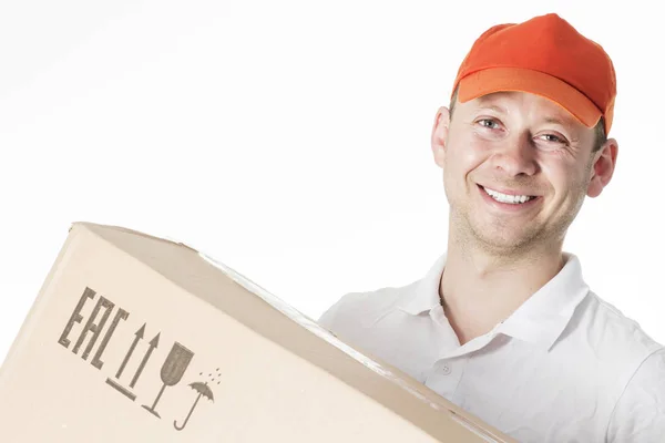 Retrato de mensajero masculino sonriente en gorra naranja con caja de cartón en manos aisladas sobre fondo blanco. Entrega concepto de mensajero — Foto de Stock