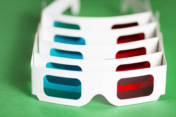 Papier 3D-Brille in Reihe auf grünem Hintergrund. Den Film im Kinokonzept anschauen. Der Film ist in 3D. — Stockfoto