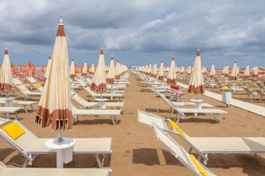 İtalya 'daki Rimini sahili. Güverte sandalyeleri ve umbr ile tatil köyü.