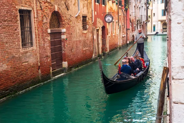 Італія, Гондульє везти людей в Гондолі на вузькому каналі V. — стокове фото