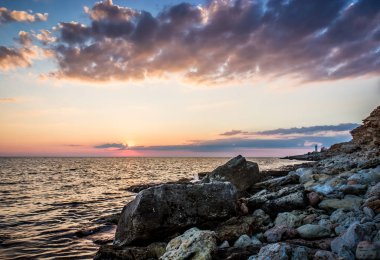 Günbatımı ovee deniz ve kayalar