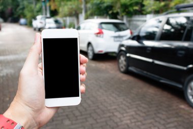 Blur araba ile boş ekran gösteren Akıllı telefon tutan adam el
