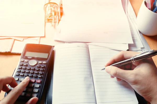 Joven hombre de negocios escribiendo hacer informe de la nota y contando cálculo — Foto de Stock