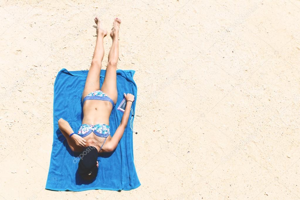 Top view and copy space of slim woman is lying sunbathe on the beach