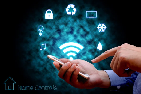 Hombre usando el teléfono inteligente o el control remoto del hogar en línea home automat —  Fotos de Stock