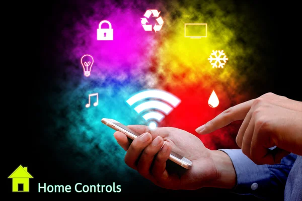 Hombre usando el teléfono inteligente o el control remoto del hogar en línea home automat —  Fotos de Stock
