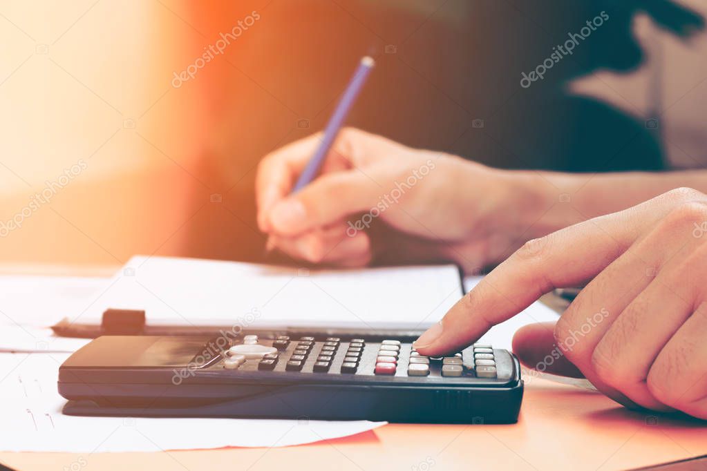 Close up young woman with calculator counting making notes at ho