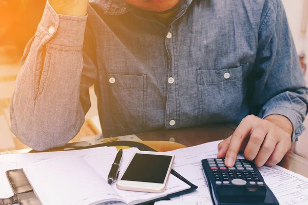 Man counting using calculator and stress in problem with expense