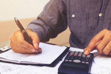 Ekonomi kavramı. Yazma işadamı ve maliyeti hakkında not yapmak.