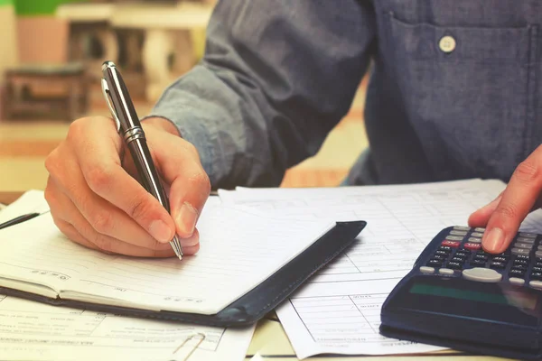 Joven hombre de negocios escribir y tomar nota sobre el costo . — Foto de Stock