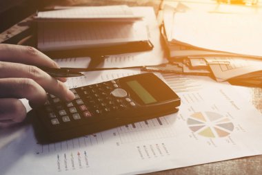 Elinde kalem tutan ve ev maliyeti hakkında düşünme işadamı 