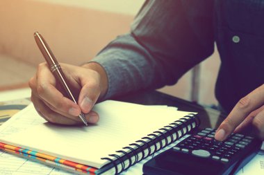 Mali ile hesap makinesi kullanma ve yazma yapan Asyalı genç erkek