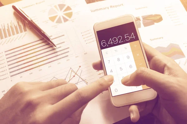 Člověk dělá finance s držení a používání kalkulačky v smartphon — Stock fotografie