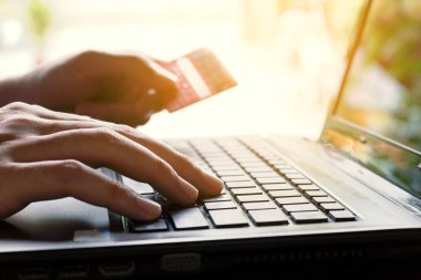 Kredi kartı tutan ve sho ile laptop klavye yazarak kadın