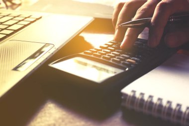 El kadın closeup hesap makinesini kullanarak ve yaklaşık maliyeti hesaplamak