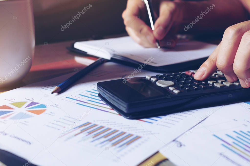 Woman calculate about expenses and making note on table at home 