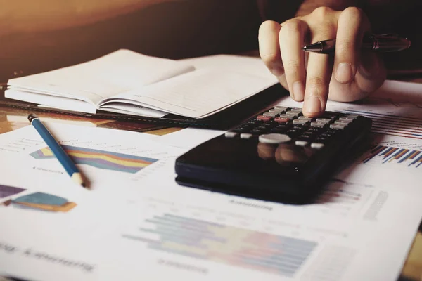 Taschenrechner mit Frauenhand, der Finanzen macht und Ersparnisse berechnet. — Stockfoto