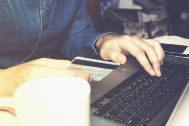 Tuş takımında yazarak ve onli alışveriş kartı tutan işadamı