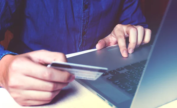 Крупним планом азіатський молодий чоловік використовує ноутбук і тримає кредитну картку wi — стокове фото