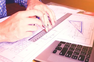 Genç Asyalı adam mimar blueprint comp çizim ile çalışma