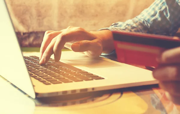 Homem mão digitando teclado laptop e segurando cartão de crédito para loja — Fotografia de Stock