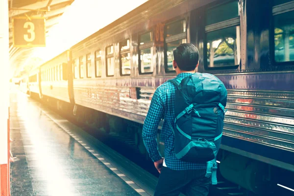 Detrás de asiático joven de pie y esperando tren en la plataforma . — Foto de Stock