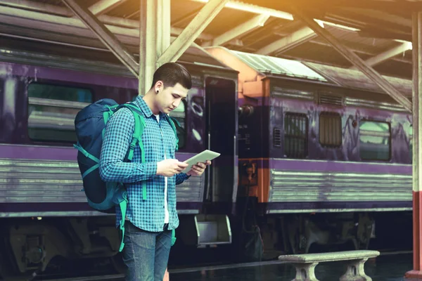 Hipster akıllı bir adam arıyorum ile tablet tren st Ekran bekleme