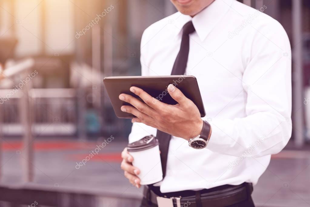 Morning time of young confident man economist holding digital ta