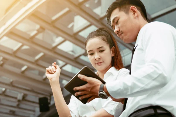 Asian business couple talking about result and looking data on t — Stock Photo, Image