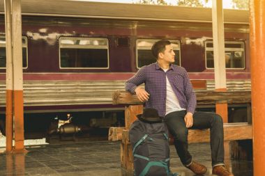 Yalnız adam bekleyen tren tren istasyonunda.