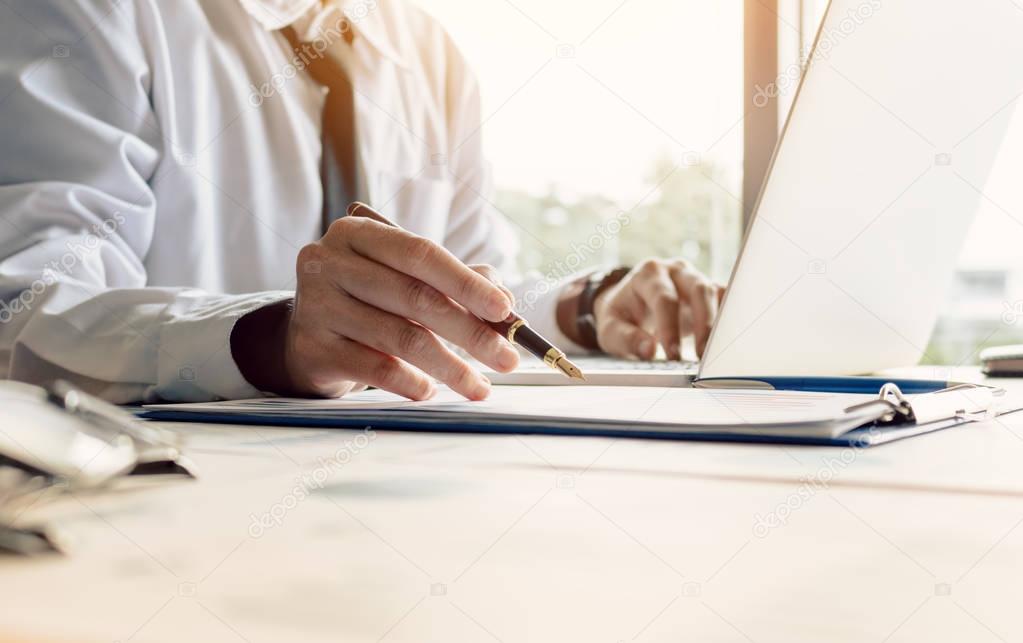 Businessman sitting at office room holding pen pointing summary 
