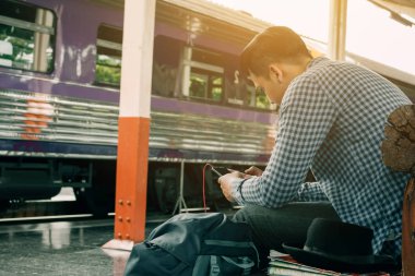 Yakışıklı genç Asyalı adam görünümlü akıllı telefon ve müzik ile oynamak