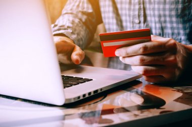 Kredi kartı tutan ve klavye laptop f yazarak Asya genç adam