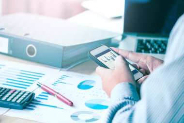 İşadamı el smartphone ve analiz veri sonucu bakarak 