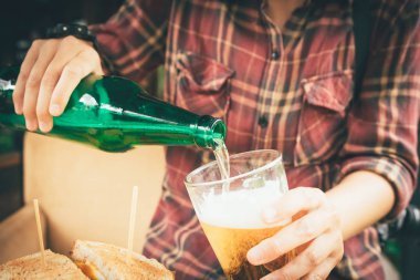 Şişe bira tutarak ve bardağa dökme barmen.