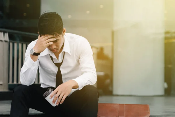 Aziatische man zit op de trappen van een kantoorgebouw met stress een — Stockfoto