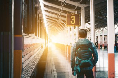 Hipster adam platformu tren istasyonu bekleyen ve looki ayakta