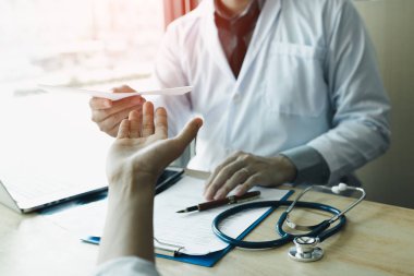 Erkek Doktor hastaya reçete teslim.