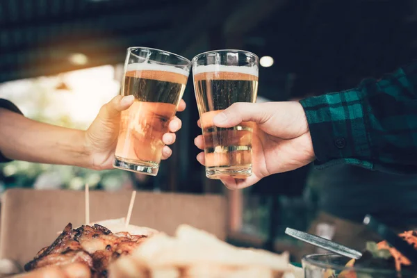 Zwei Freunde stoßen mit einem Glas Bier an und klirren. — Stockfoto