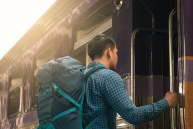 Arkadan görünüş hansome Asya adam ayakta ve trende alarak.