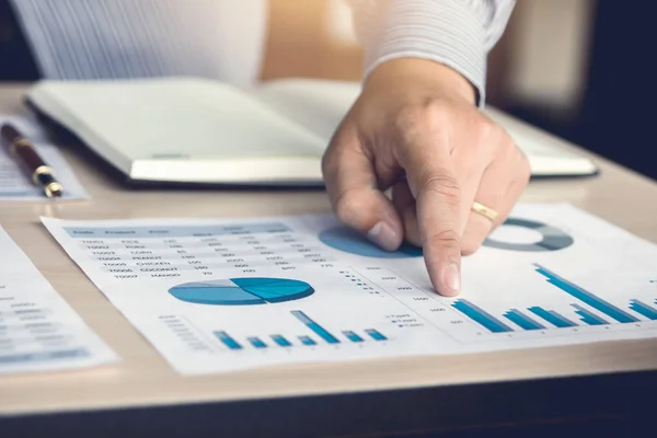 Mano hombre apuntando número en el informe gráfico . — Foto de Stock