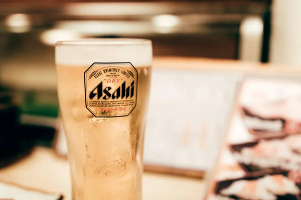 OSAKA, JAPÃO - 17 de janeiro de 2018: Cerveja Asahi em um copo de madeira — Fotografia de Stock