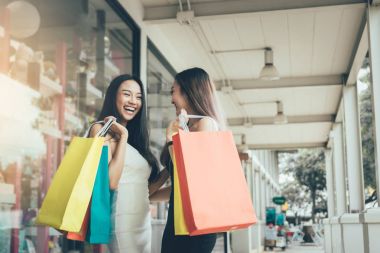 İki kişi Asyalı kadın çıkış saatinde alışveriş hakkında mutlu ve komik