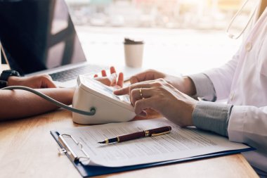 Doktor hastaya hastanede basınç göstergesi düğmesine basarak.