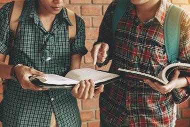 İki öğrenci okuma kitabı birlikte okulda Kütüphane odasında.