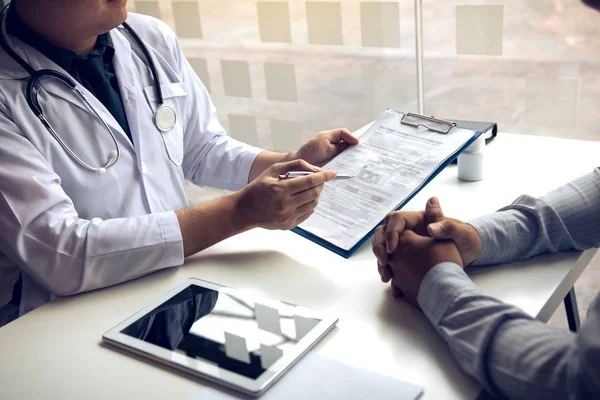 El doctor está escribiendo la carta de cita al paciente en la c — Foto de Stock