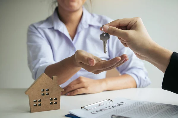 Рука агента з нерухомості передає ключ новим домовласникам в — стокове фото